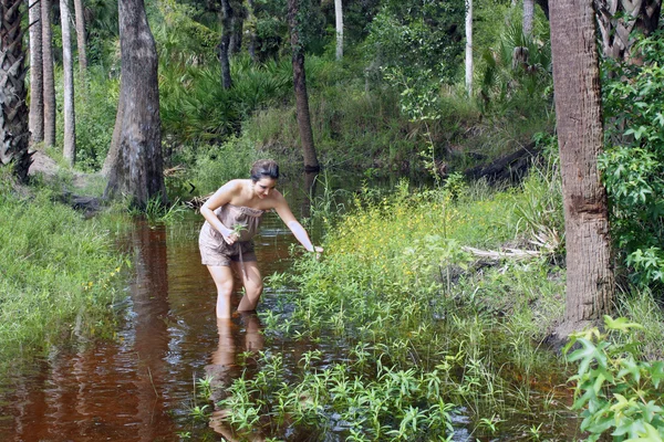 Brunette Picks Wildflowers in a Swamp — Stock Photo, Image