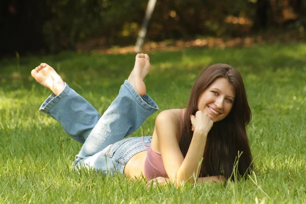 Mooie jonge Brunette liggen in gras (3) — Stockfoto