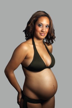 Smiling Bikini-clad Woman Eight Months Pregnant clipart