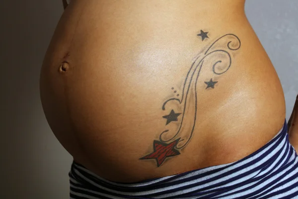 Беременная женщина живот с татуировкой (1 ) — стоковое фото