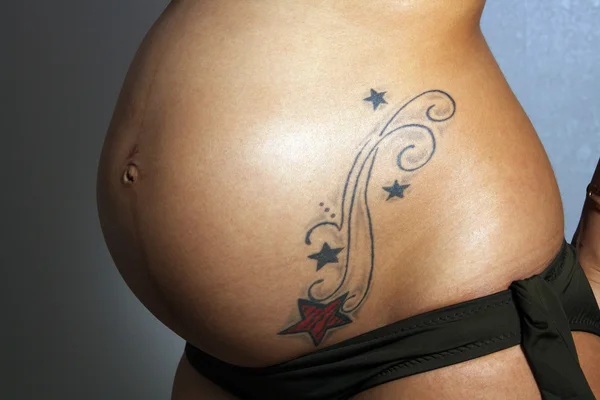 Barriga feminina grávida com tatuagem (2 ) — Fotografia de Stock