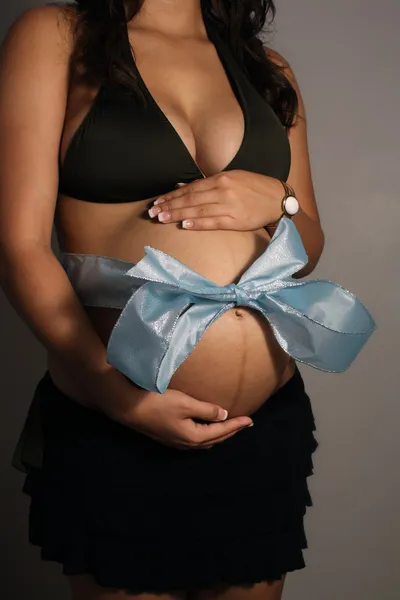 Torse féminin enceinte avec noeud bleu — Photo
