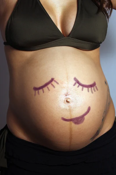 Gyermek-, mint mosolygó arc a terhes nő — Stock Fotó
