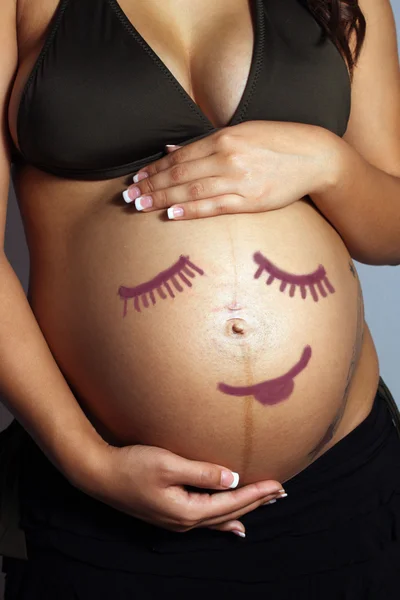 Детский смайлик на беременную женщину — стоковое фото