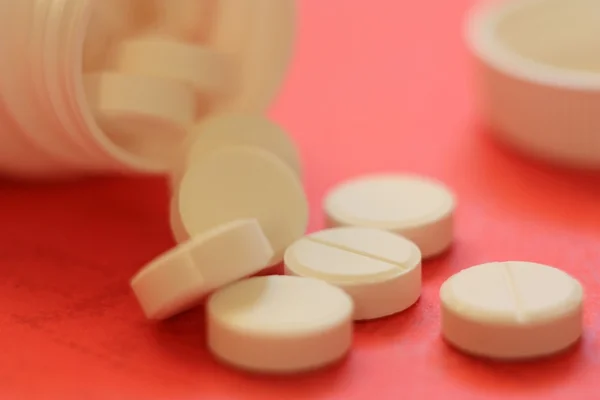 Białe tabletki rozlane ze słoika — Zdjęcie stockowe