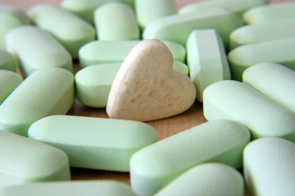 Tabletki w formie serca światło zielone pastylki — Zdjęcie stockowe