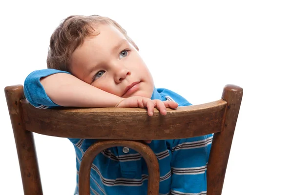 Ledsen pojke sitter på stol — Stockfoto