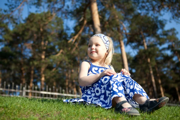 Beautiful girl sitting on green grass — Stock Photo, Image