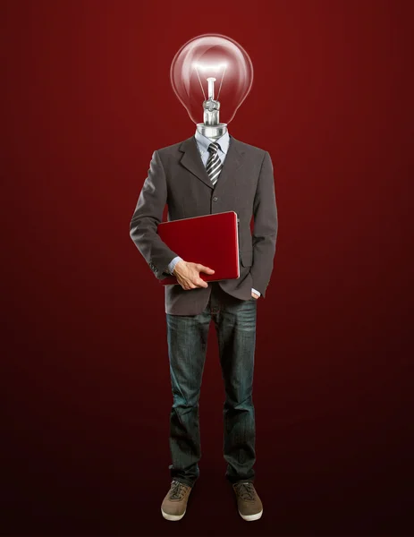 Мужчина в костюме с лампой и ноутбуком в руках — стоковое фото