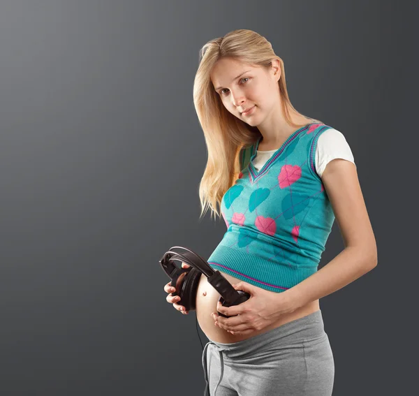 ヘッドフォンで妊娠中の女性 — ストック写真