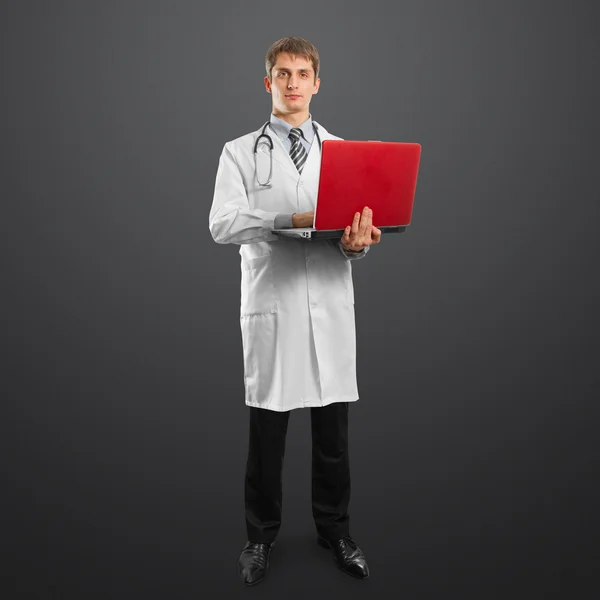 Médico macho de terno com laptop em suas mãos — Fotografia de Stock