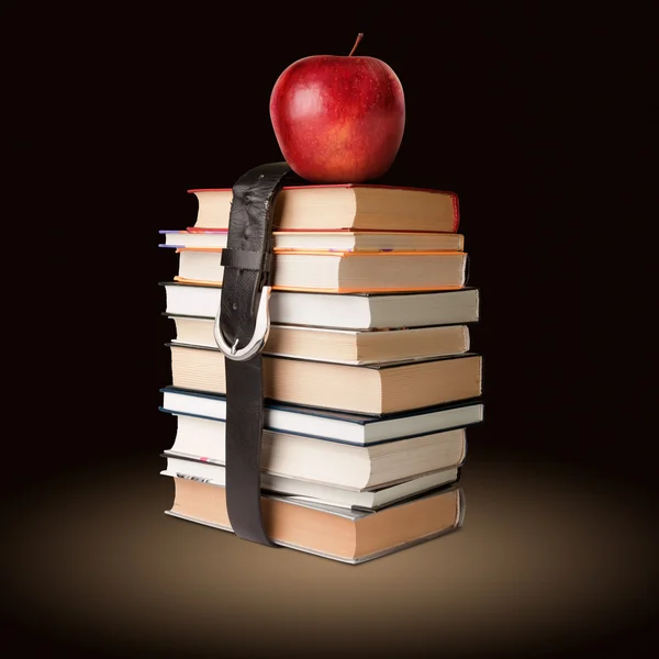 Pila de libros con cinturón y manzana — Foto de Stock