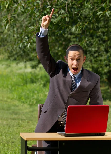 Man met rode laptop buitenshuis werken — Stockfoto