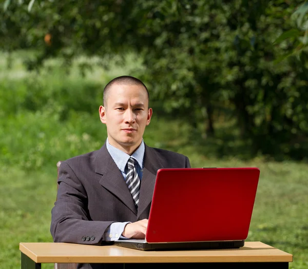 Uomo con computer portatile che lavora all'aperto — Foto Stock