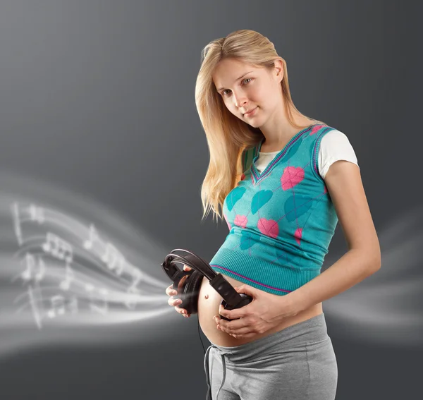 Femme enceinte avec écouteurs — Photo