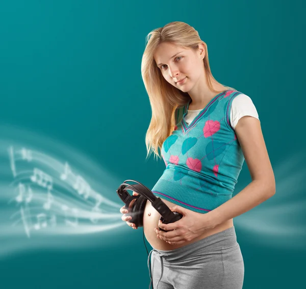 Femme enceinte avec écouteurs — Photo