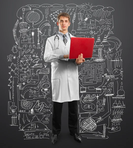 Médico macho de terno com laptop em suas mãos — Fotografia de Stock