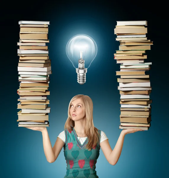 Donna con molti libri in mano e lampadina — Foto Stock