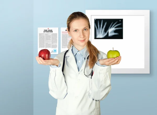 Femme médecin avec deux pommes — Photo