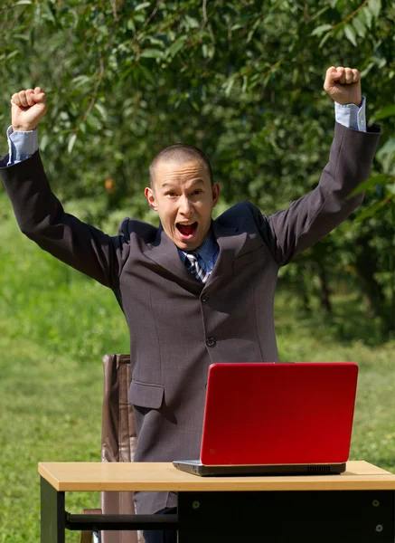 야외에서 일 하는 빨간 노트북을 가진 남자 — 스톡 사진