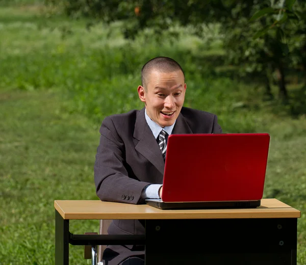 Człowiek z czerwony laptop działa na zewnątrz — Zdjęcie stockowe