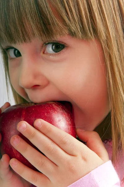 Klein meisje eet appel — Stockfoto
