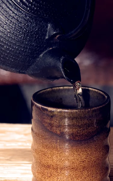 Stock image Pouring tea from teapot into a matching tea cup