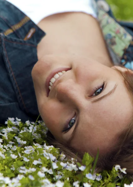 Kobieta leżąc na łące kwiatów — Zdjęcie stockowe