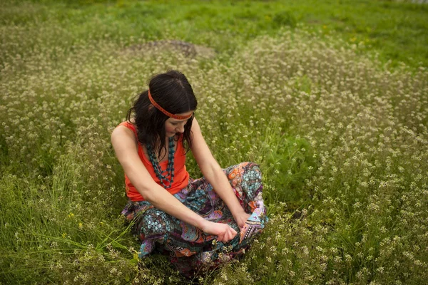 Vrouw zittend in het gras — Stockfoto