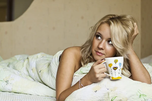 Blonde with a mug in bed — Stock Photo, Image