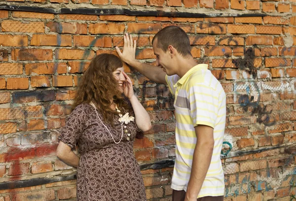 stock image Portrait of a happy young man kisses his pregnant wife . outdoor .