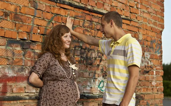 Ritratto di un giovane felice bacia la moglie incinta. all'aperto  . — Foto Stock