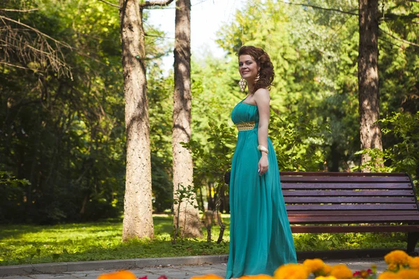 En charmerende kvinde i en blå kjole - Stock-foto