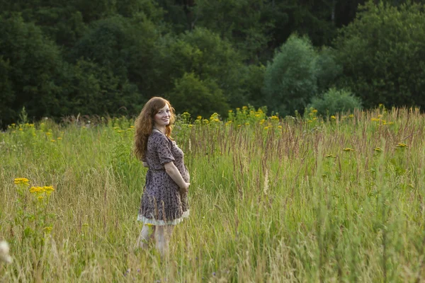 Беременная молодая женщина в поле — стоковое фото
