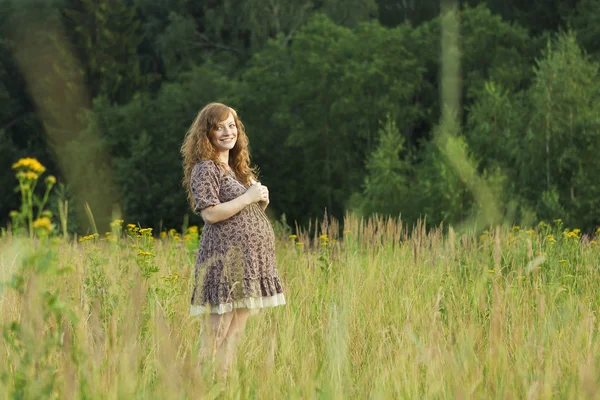 Uma jovem grávida em um campo — Fotografia de Stock