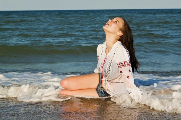 Beautiful brunette lying on the beach — Stock Photo, Image