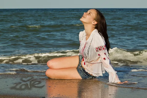 Mooie brunette liggend op het strand — Stok fotoğraf