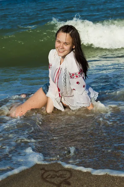Mooie brunette liggend op het strand — Stockfoto