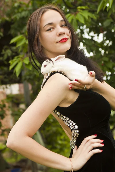 Beautiful brunette holding a white rabbit — Stock Photo, Image
