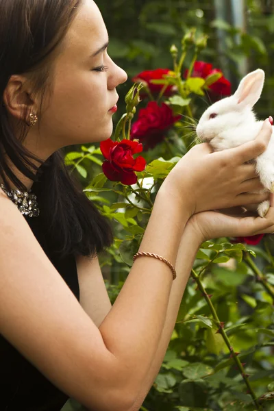 Güzel esmer beyaz bir tavşan tutarak — Stok fotoğraf
