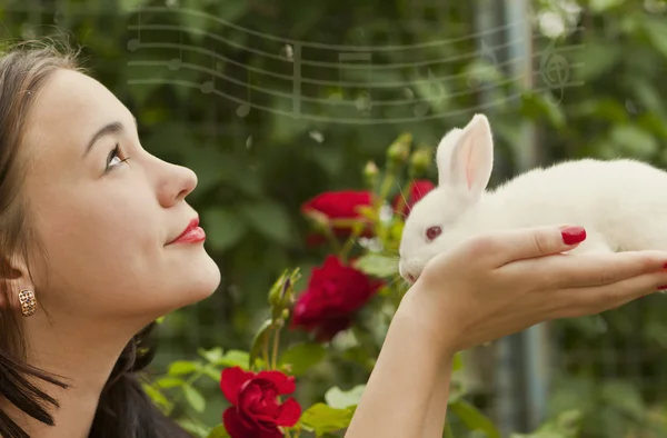 Linda morena segurando um coelho branco — Fotografia de Stock