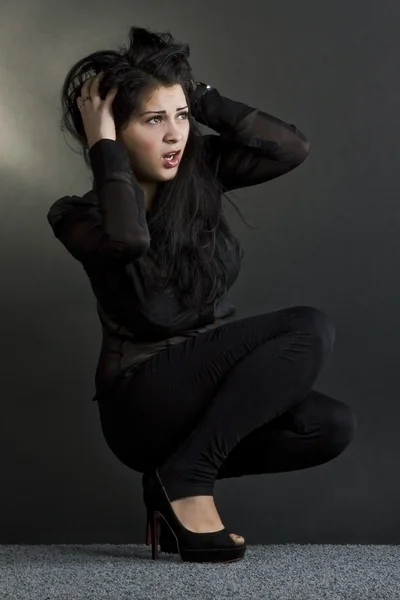 Egy gyönyörű sötét hajú lány cserzett egy fekete háttér portréja — Stock Fotó
