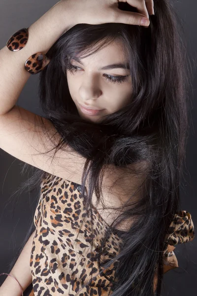 Retrato de una hermosa chica morena bronceada sobre un fondo negro — Foto de Stock