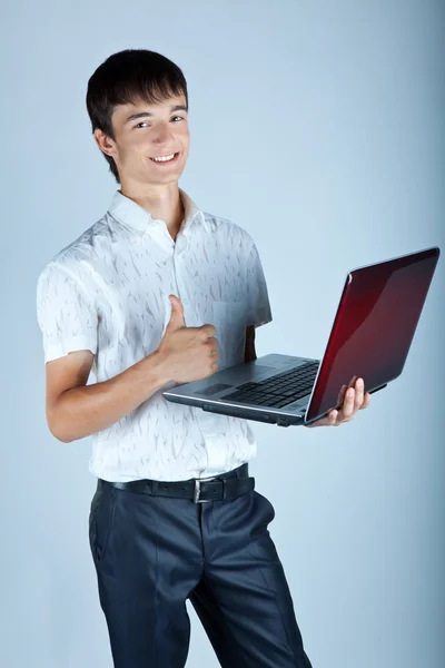 Pohledný mladý muž drží notebook — Stock fotografie
