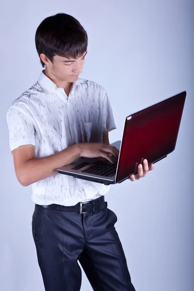Pohledný mladý muž drží notebook — Stock fotografie