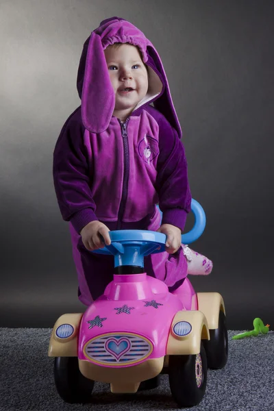 Menina engraçada com um carro de brinquedo — Fotografia de Stock