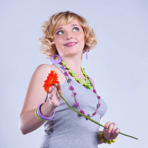 Linda jovem loira encaracolado mulher com uma flor — Fotografia de Stock