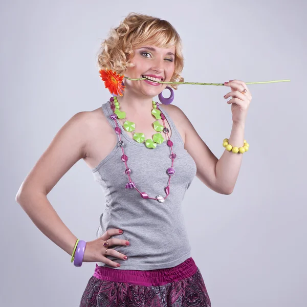 Beautiful young blond curly woman with a flower — Stock Photo, Image
