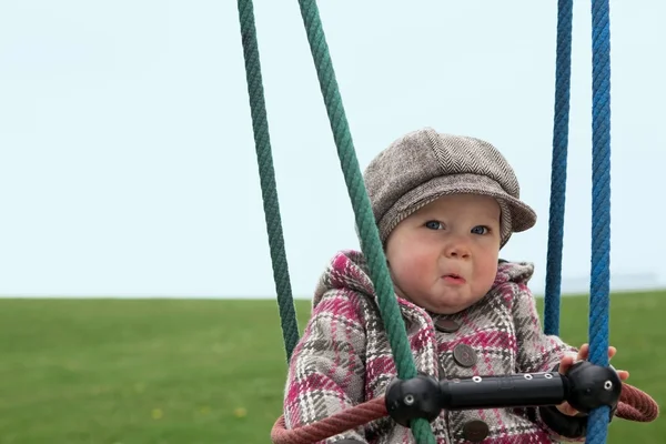 Sad baby girl on a swing — Stock Photo, Image