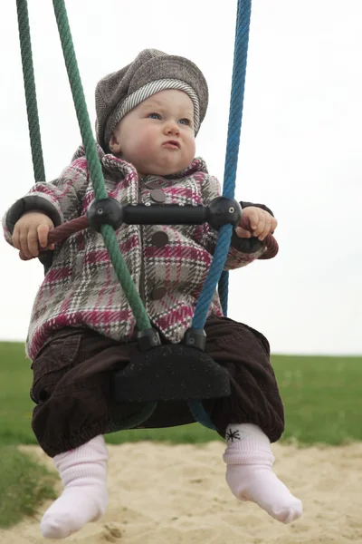 Bebê menina em um balanço — Fotografia de Stock